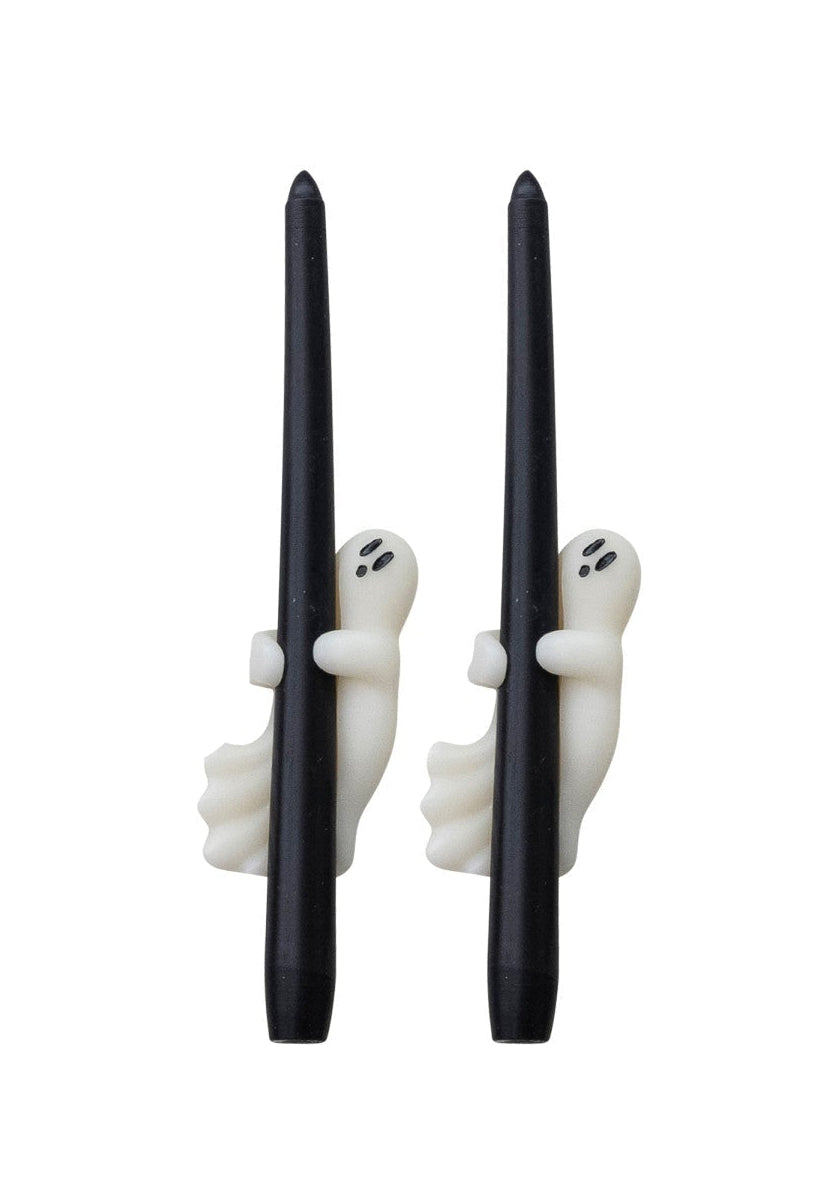 Set of black candles with ghost decorations in packaging on a white background