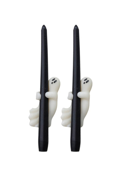 Set of black candles with ghost decorations in packaging on a white background