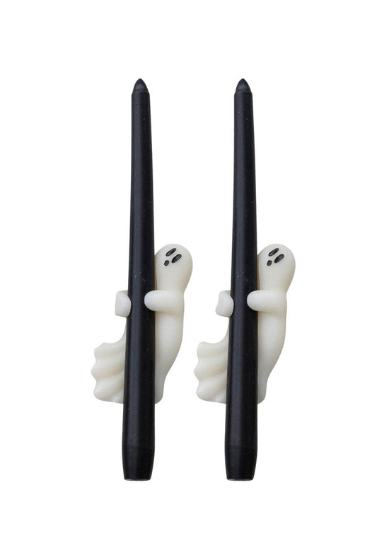 Set of black candles with ghost decorations in packaging on a white background